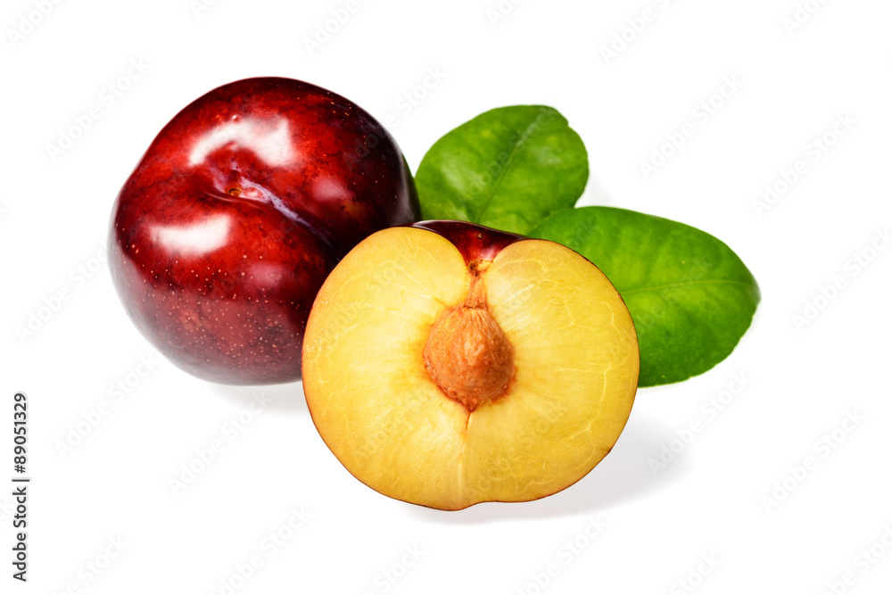 half of fresh red plum on white half of fresh red plum on white