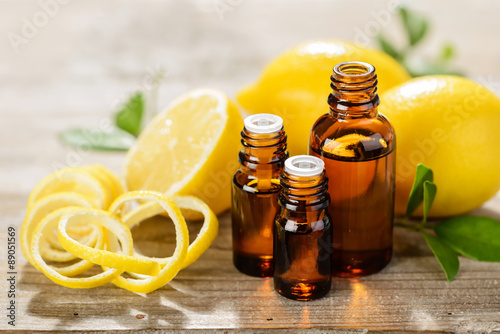 lemon essential oil and lemon fruit on the wooden board, (taken with tilt shift lens) photo