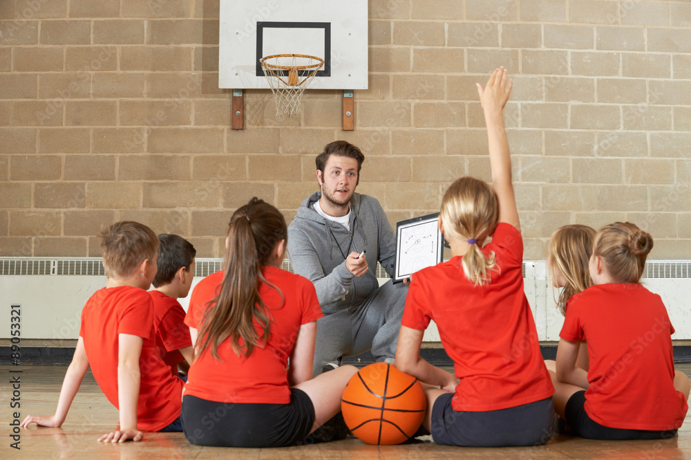 Fototapeta premium Coach Giving Team Talk To Elementary School Basketball Team