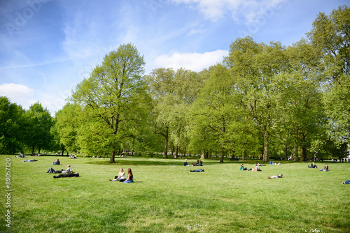 Fototapeta Naklejka Na Ścianę i Meble -  People lying on grass relaxing in a London Park