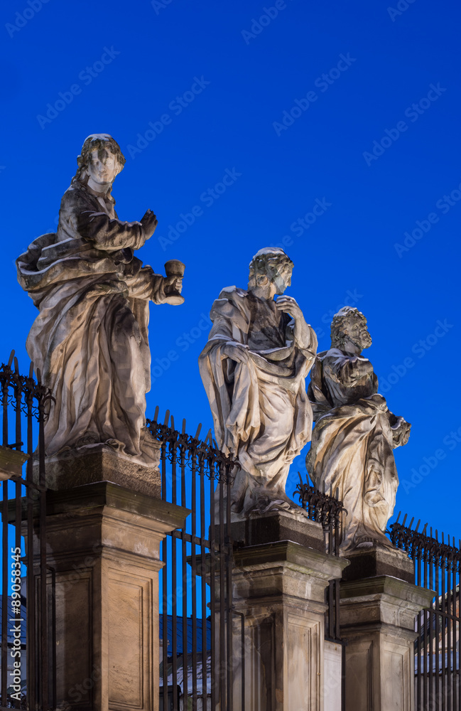 Obraz premium Baroque sculptures of the Apostles on the plinths in front of the Saints Peter and Paul church in Krakow illuminated in blue hour