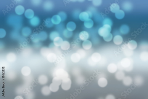 Snowy blurry winter holiday background in white and blue; snowy landscape. Bokeh effect; illustration.