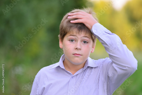 Astonished boy holding his hands behind  head photo