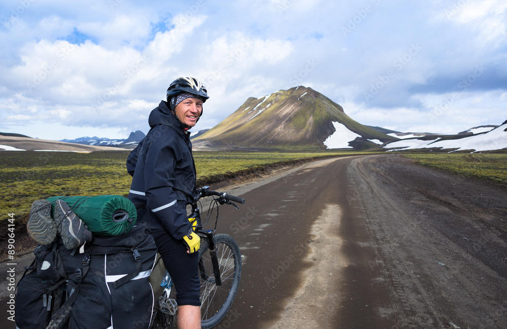 Happy biker on backdrop of volcanic mountains in Iceland Happy biker on backdrop of volcanic mountains in Iceland