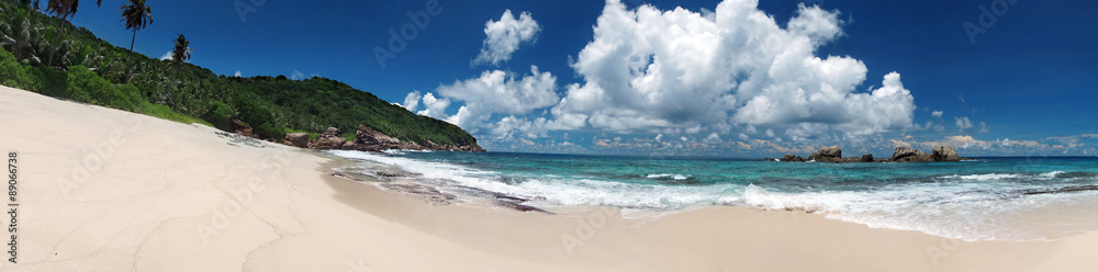 Tropical sandy beach with clouds and blue sky at summer sunny day, panorama 