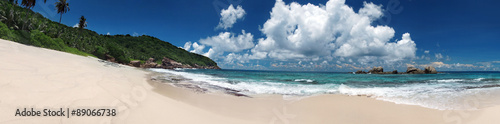 Tropical sandy beach with clouds and blue sky at summer sunny day, panorama 