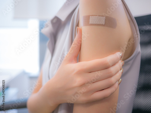Adhesive bandage on a female arm after vaccination