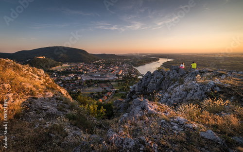 Man and Woman Looking at View of Small City with River from the © kaycco