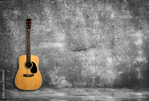 Acoustic guitar against old wall © christianchan