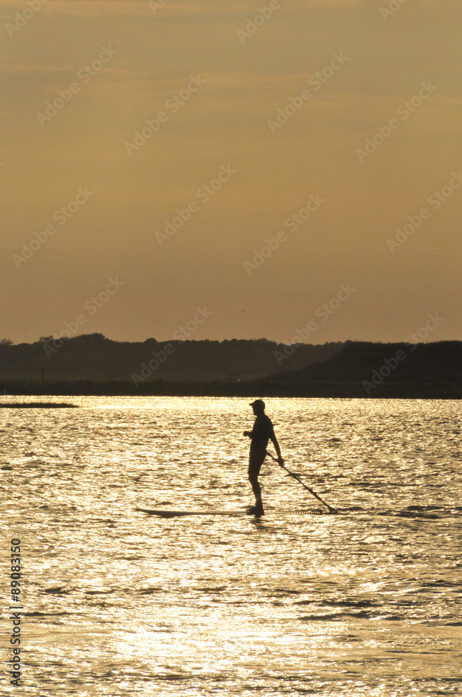 Silhouette of stand up paddler (vertical) 