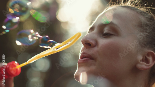 Girl Blowing bubbles in nature, colourful 