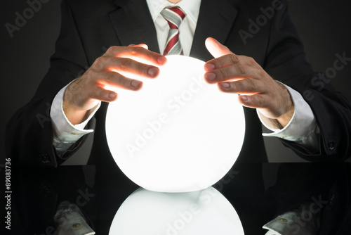 Businessman Predicting Future With Crystal Ball