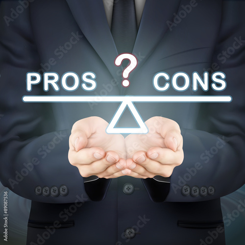 businessman holding pros and cons seesaw