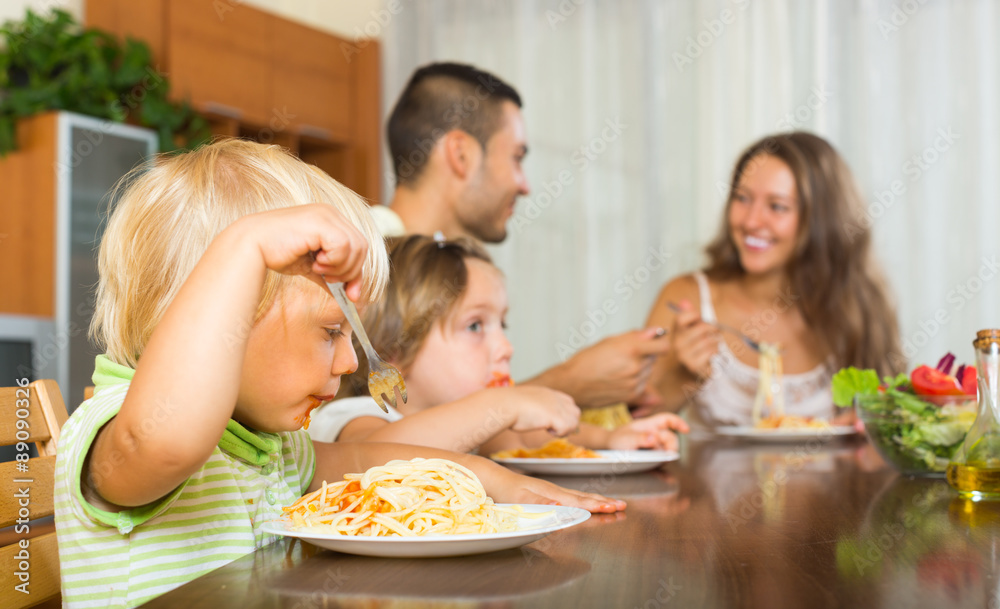 Family of four eating spaghetti