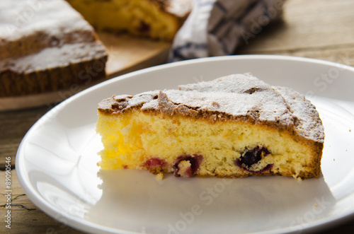  piece of cake with black currants and sugar on wooden table