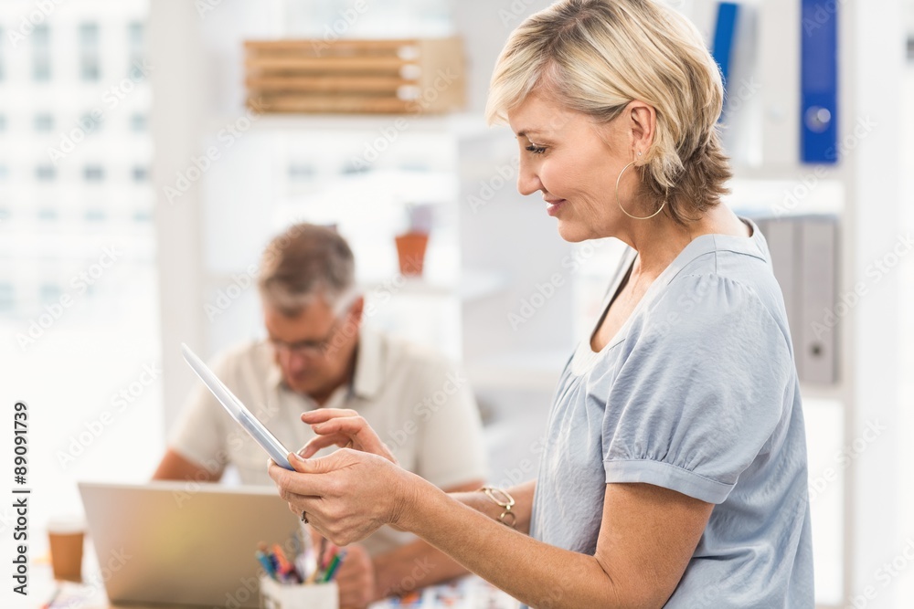 Smiling businesswoman scrolling on a tablet