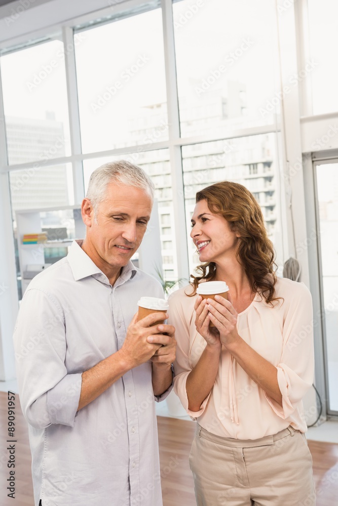 Smiling casual business colleagues having coffee together