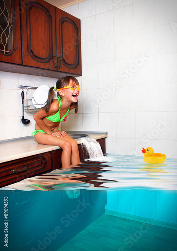 Child girl make mess, flooded kitchen imitating swimming pool, f