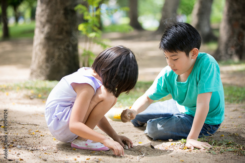 Little Asian child playing sand in the park