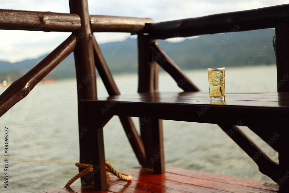 A Glass of alcohol with ice beside river A Glass of alcohol with ice beside river