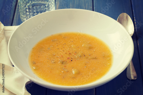 vegetable soup in white plate on blue background photo