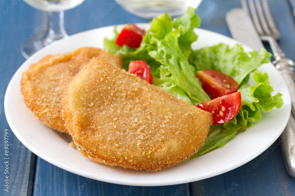 portuguese meat cookies with fresh salad on white dish on blue background portuguese meat cookies with fresh salad on white dish on blue background