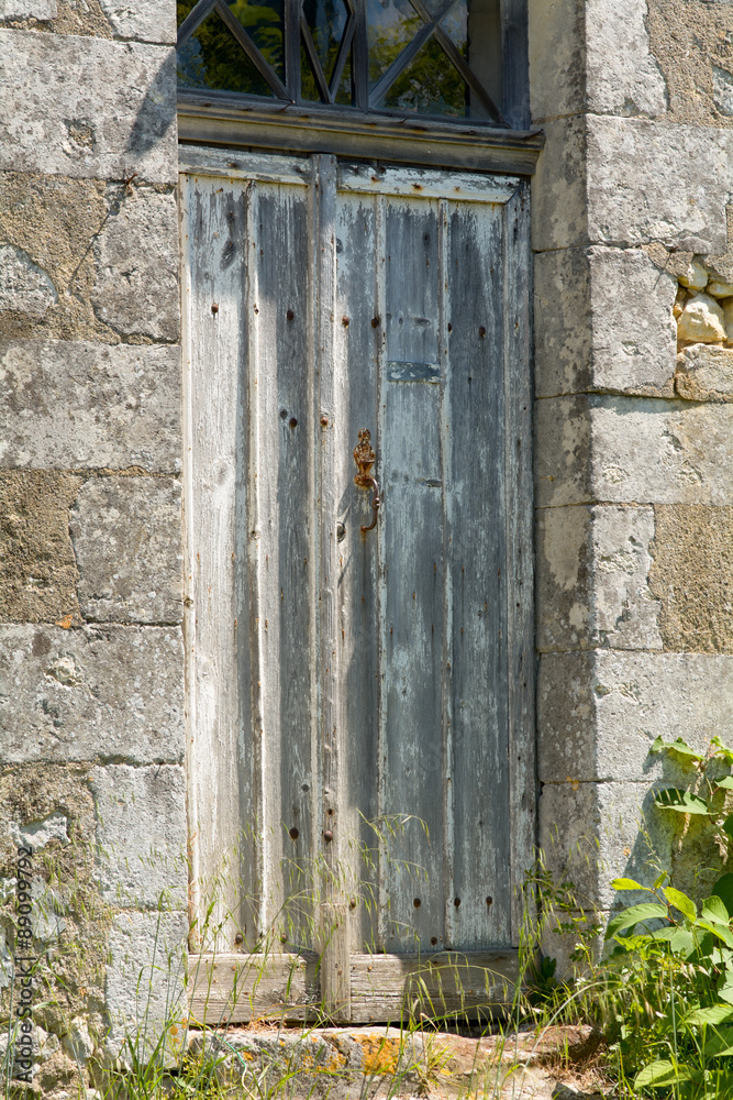 Old battered and damaged wooden door to French home Old battered and damaged wooden door to French home