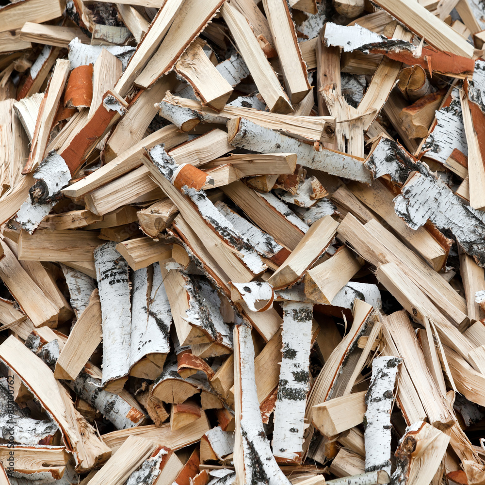 Birch firewood in a pile in the background Birch firewood in a pile in the background