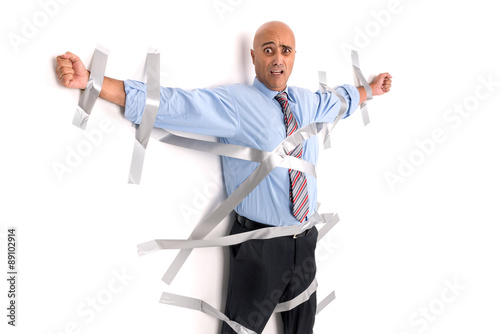 Businessman glued to the wall photo