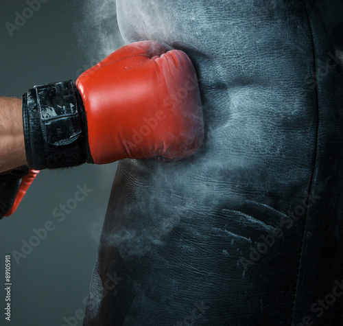 Hand  of boxer and punching bag over black background © master1305