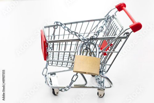 Tied up trolley with padlock. Conception of keeping shopping under control.