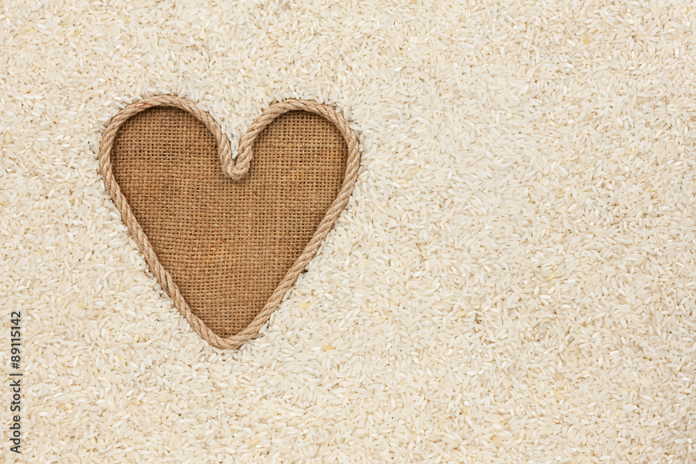 The symbolic heart made of rope lies on sackcloth and rice grain The symbolic heart made of rope lies on sackcloth and rice grain