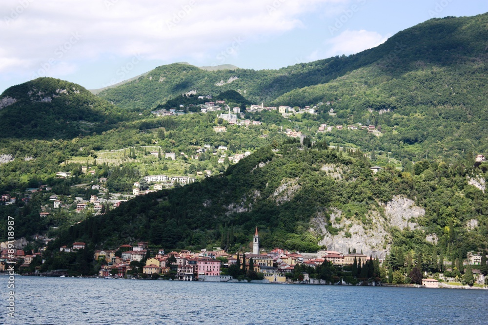 Varenna lake front at the Lake Como under blue sky in Lombardy Italy, photographed from the car ferry, 