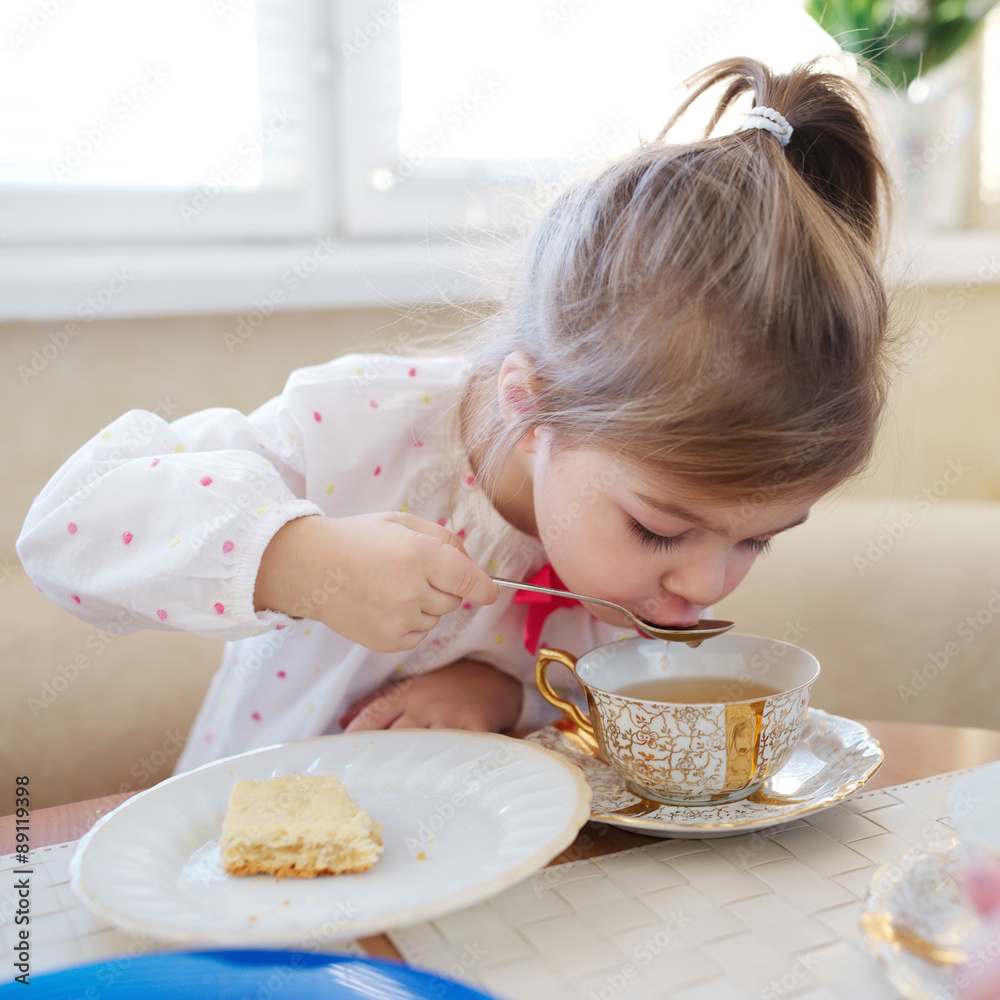 cute little girl drinks tea