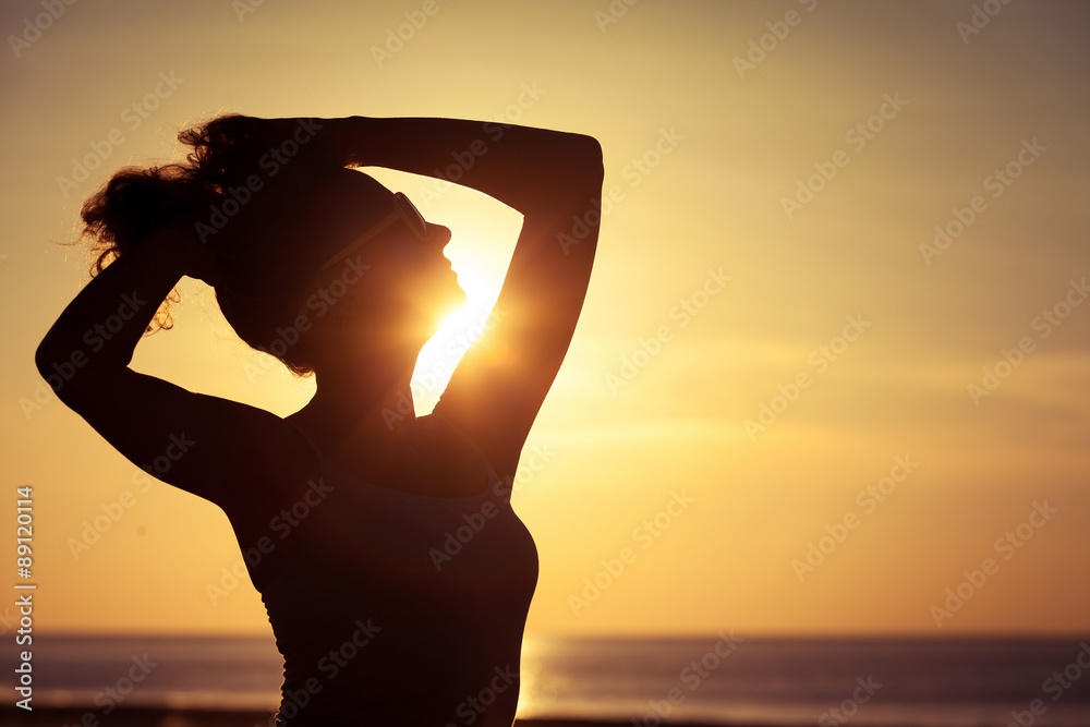 woman open arms under the sunset at sea