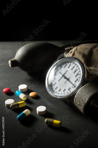 Sphygmomanometer with medicine pills and capsules.