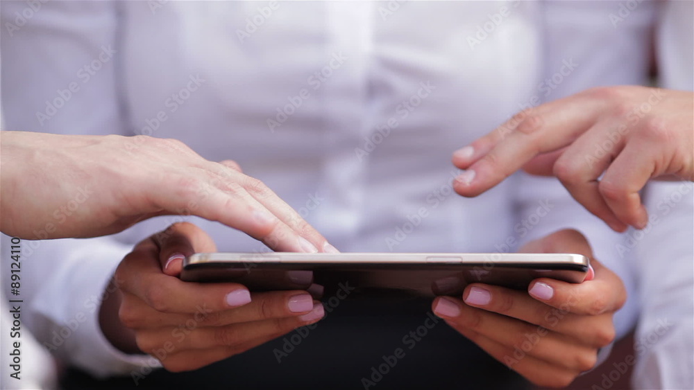 Close up of usage of a tablet by several people Close up of usage of a tablet by several people