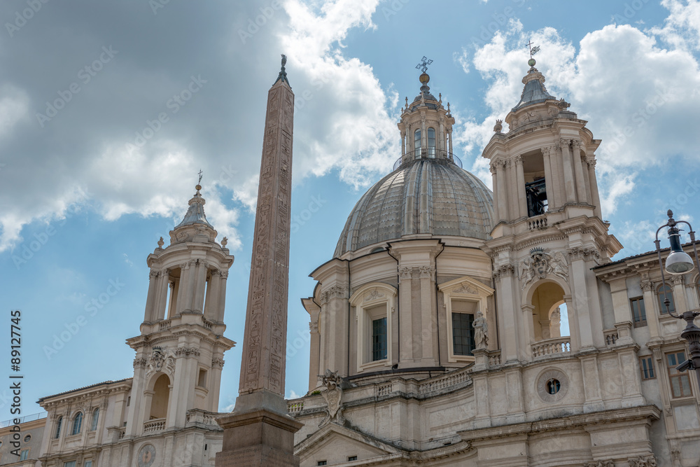 Teilansicht der Kirche Sant’Agnese in Agone auf der Piazza Navona in Rom mit dem Obelisken des Vierströmebrunnens im Vordergrund