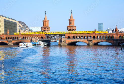Oberbaumbrücke (Oberbaum Bridge) with subway and boat on the river Spree, Berlin