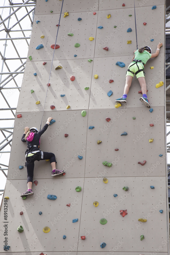 Naklejka premium women on a rock climbing wall