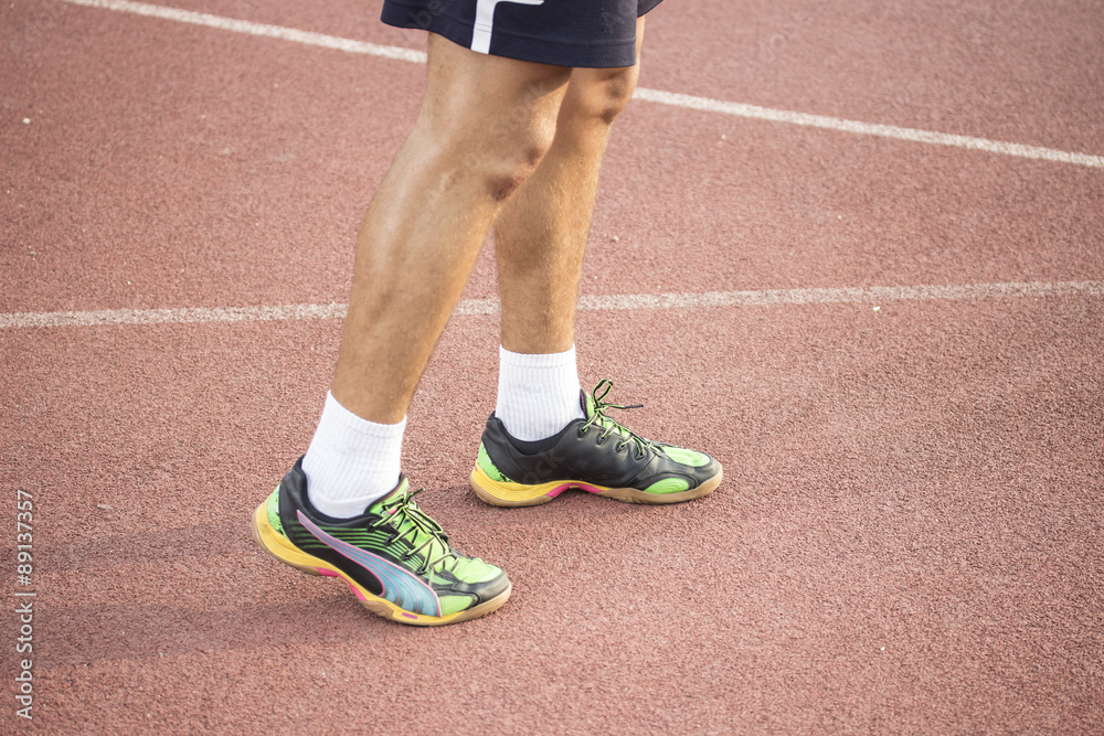 Sprinter at track, close up of legs and shoes.