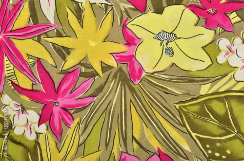 Colorful tropical floral pattern on fabric. Pink flowers with green leaves print as background.