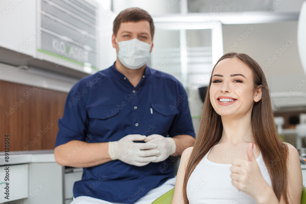 Attractive young dental doctor is treating his patient