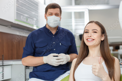Attractive young dental doctor is treating his patient