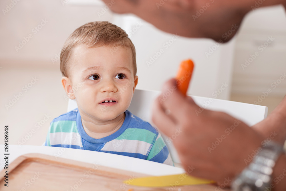 Handsome young man is preparing food for his kid Handsome young man is preparing food for his kid