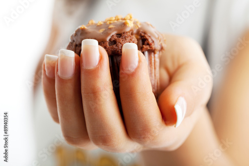 Chocolate muffin in woman's hand