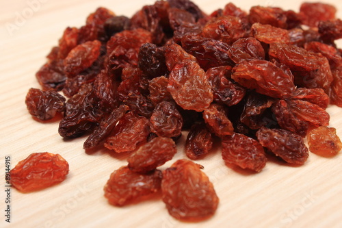 Brown raisins on wooden table, healthy eating