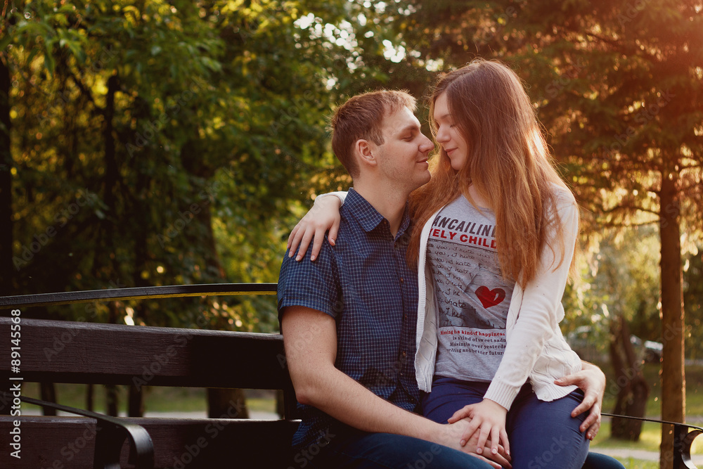 lovely young couple sitting on a seat bench lovely young couple sitting on a seat bench