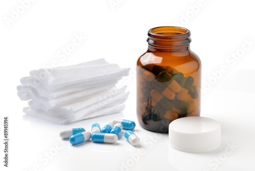 pills out of bottle and Cotton bandage on white background