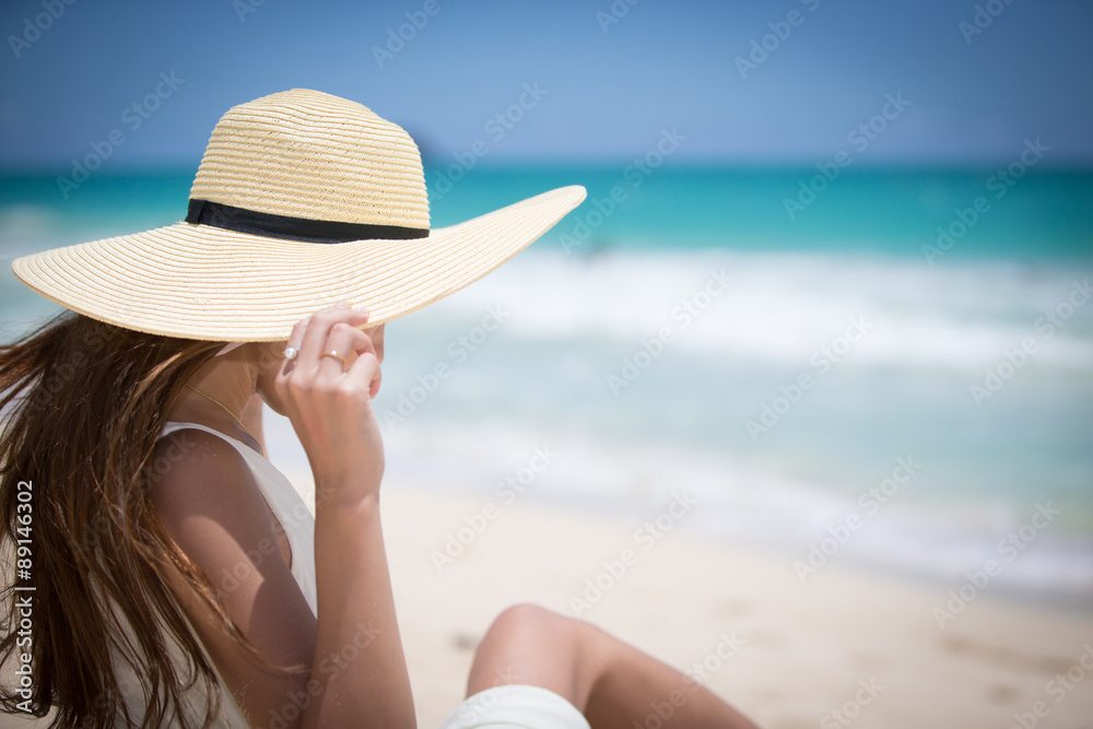 ハワイの海辺でリラックスしている女性